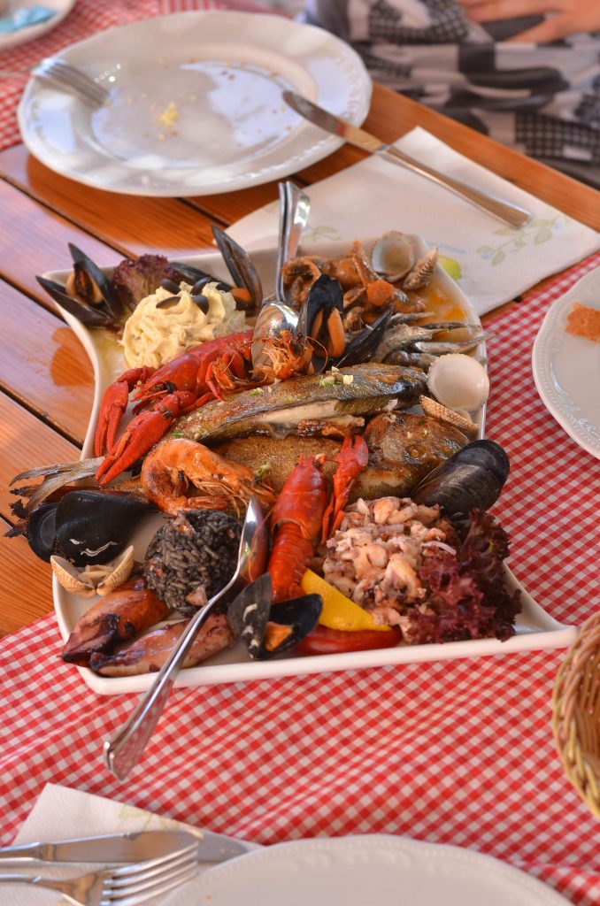 Seafood dish in montenegro, skampi  Grilled or fried squid, Octopus salad, Black risotto (with cuttlefish), Tuna, Prawns and Mussels.