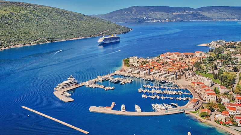 Panoramski pogled na luksuzno naselje Portonovi uz Jadransko more, sa marinom i okolnim planinama.